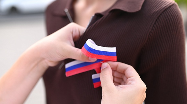 Краснодарцам ко Дню Государственного флага России раздают ленточки триколора 