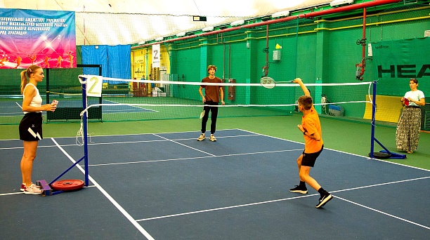 Удар ракетки - волан летит над сеткой